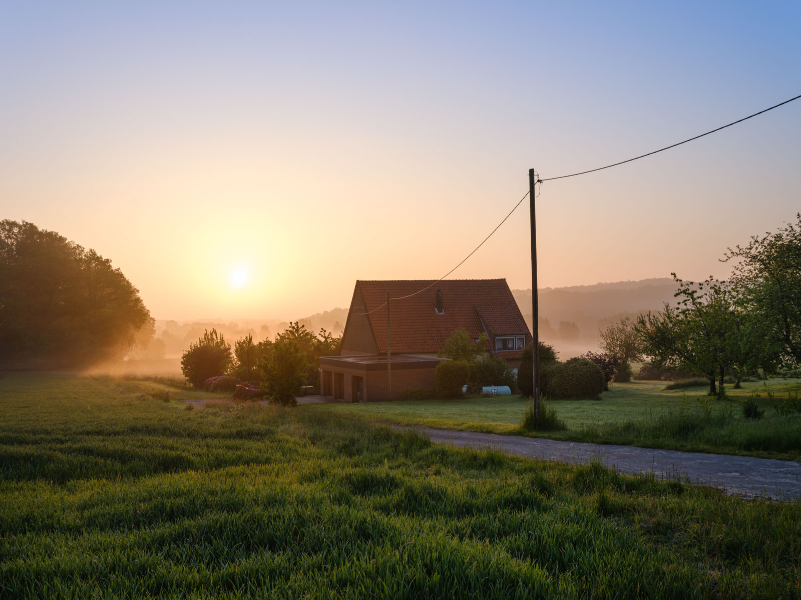 House in the fields at sunrise in May 2021 (Bielefeld-Dornberg, Germany).