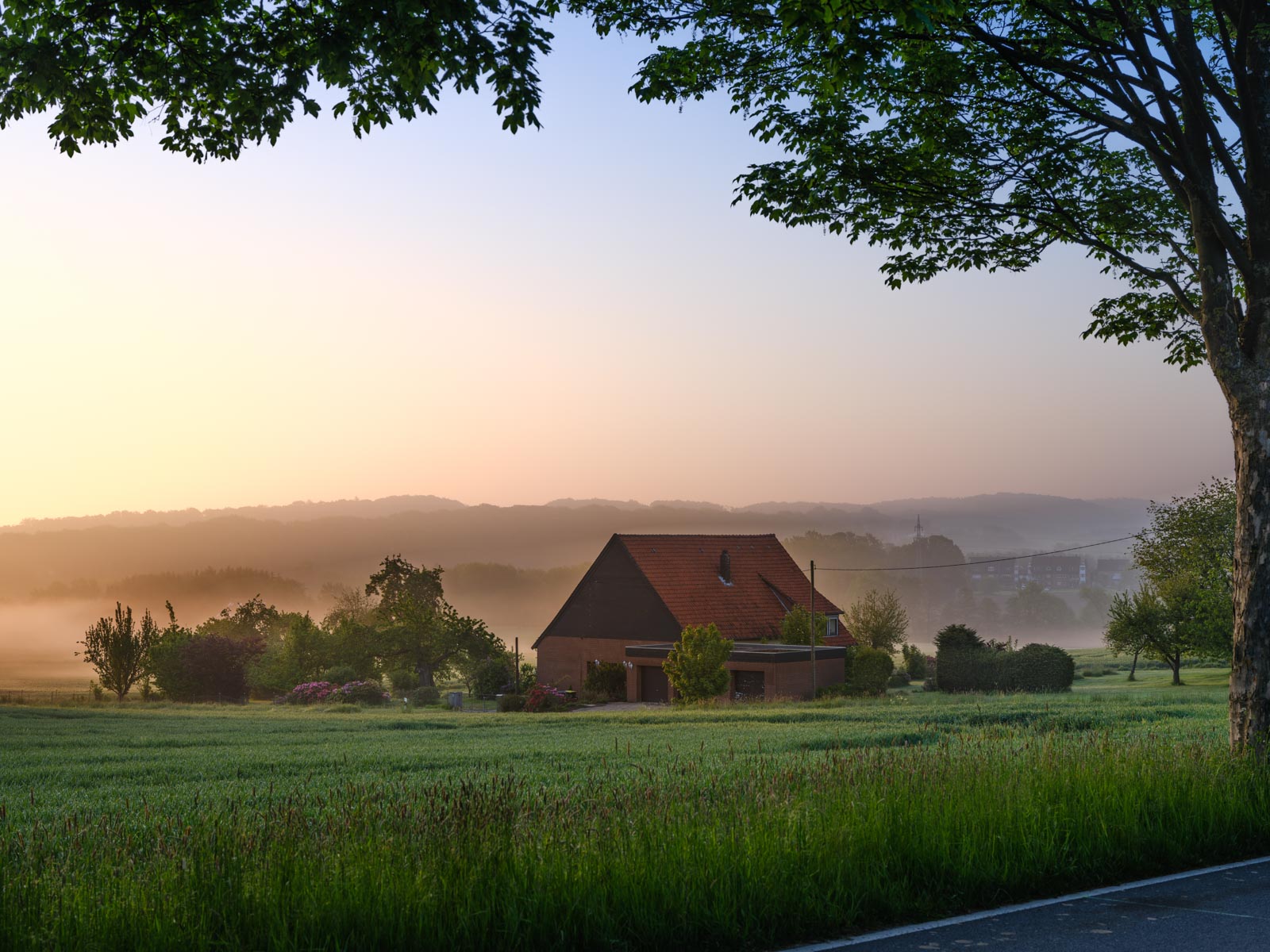 House in the fields at sunrise in May 2021 (Bielefeld-Dornberg, Germany).
