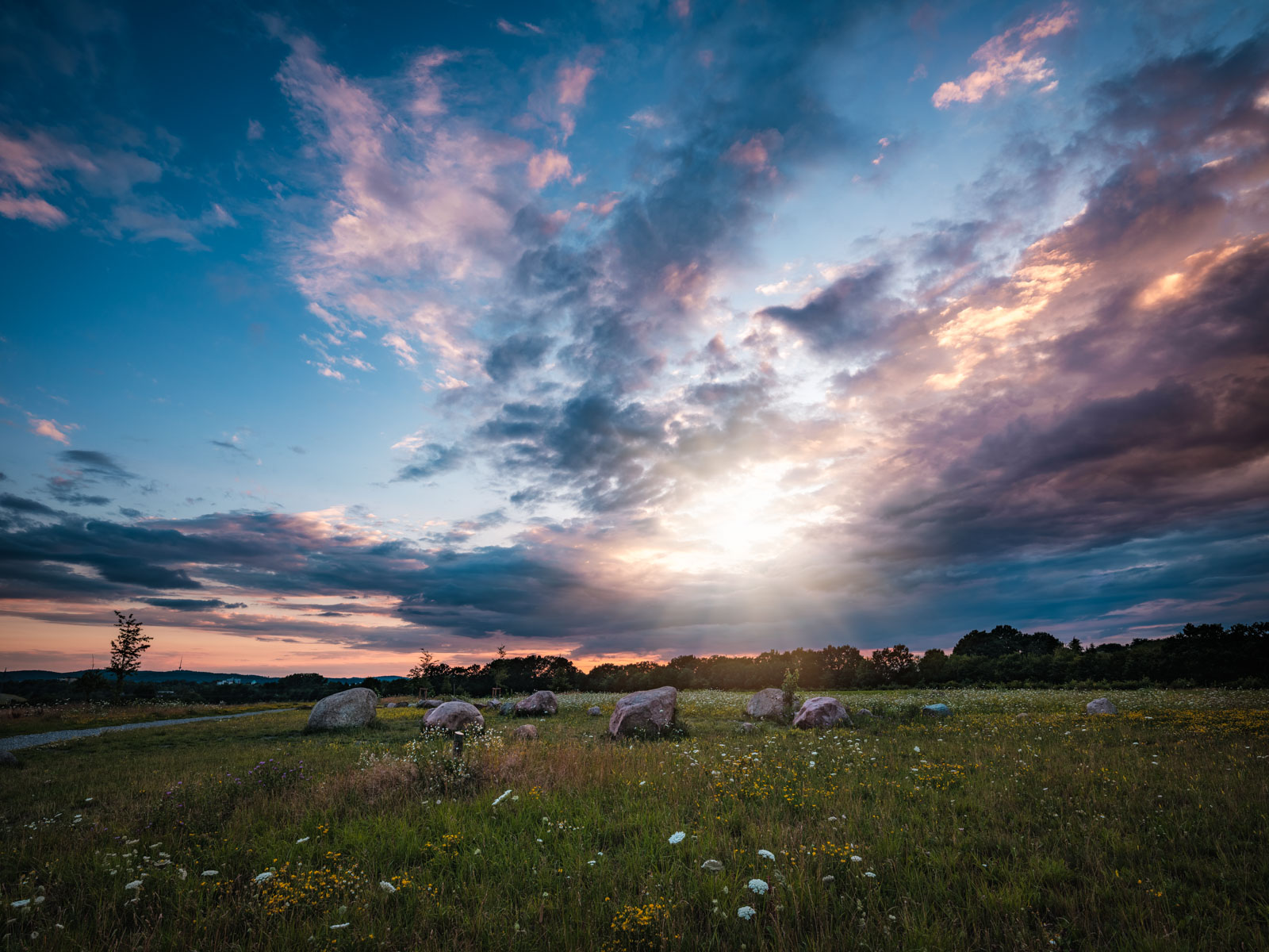 Landscape with erratic rocks at dusk in July 2020 (Bielefeld, Germany).